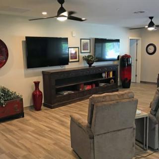 A modern living room featuring a large television, comfortable seating, and stylish decor.