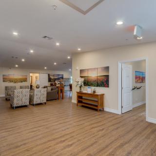 A spacious and modern living room with wood flooring, stylish furniture, and decorative artwork on the walls.