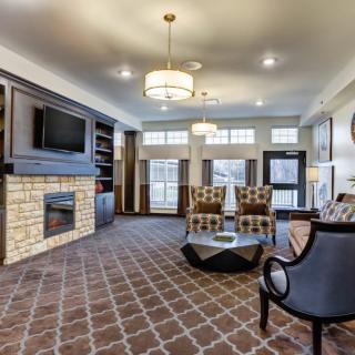 A modern living room with a cozy seating area, fireplace, and large windows.