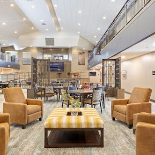 A spacious and inviting lobby featuring modern furnishings and bright lighting, perfect for relaxation and socializing.