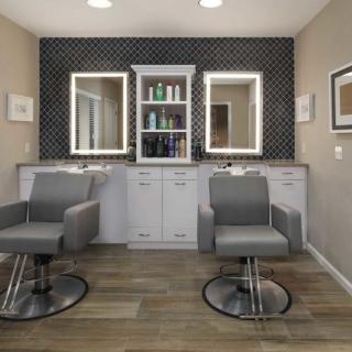 A modern hair salon interior with stylish chairs and illuminated mirrors.