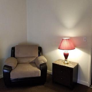 A cozy corner with an armchair, side table, and lamp.