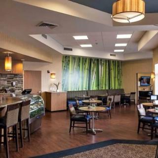 A modern cafe with a cozy seating area and decorative lighting.