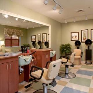 Interior view of a well-organized salon with styling chairs, hairdryers, and mirrors.
