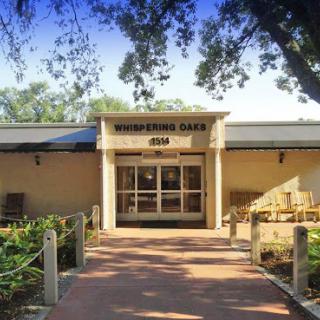 The inviting entrance of a community center surrounded by lush greenery.