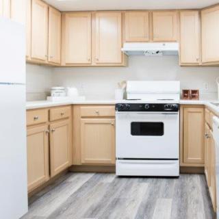 A clean and organized kitchen with light wooden cabinets and modern appliances.