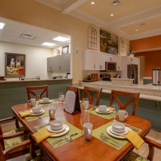 A modern dining room and kitchen area with a neatly set table.