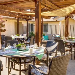 An inviting outdoor patio dining area with tables set under a pergola.