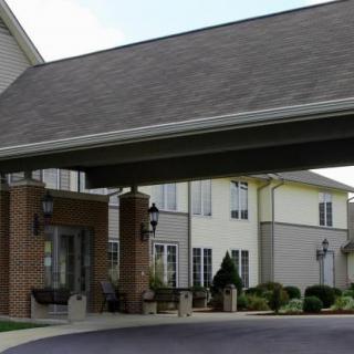 A covered entrance to a building with landscaped surroundings.
