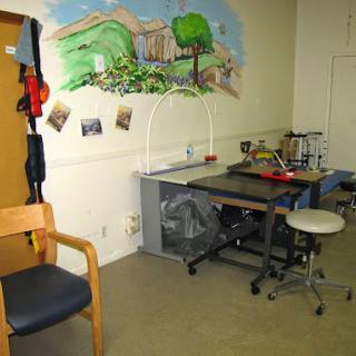 A creative workspace featuring a mural and various furniture.