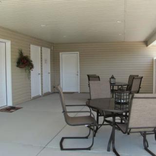 A spacious outdoor patio area with a table and chairs, providing a welcoming atmosphere.