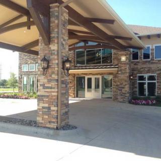 Front entrance of a stone facade commercial building with large covered walkway.