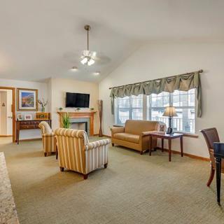 A cozy living room with comfortable seating, a television, and large windows.