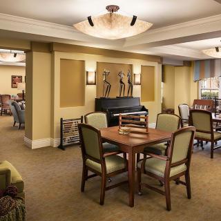 A well-furnished living area with a table and chairs, ambient lighting, and decorative artwork on the walls.