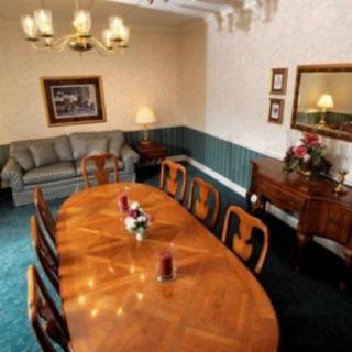 A cozy dining room with a wooden table and chairs, complemented by a sofa and decorative elements.