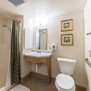 A clean and simple bathroom with a shower, sink, and toilet.