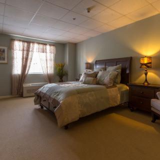 A cozy and well-decorated bedroom with elegant lighting and comfortable furnishings.