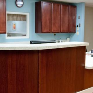 A reception area with a wooden counter and cabinets.