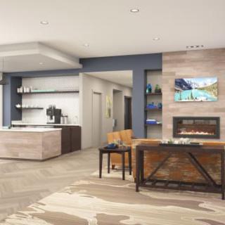 A modern open-plan living room with a kitchen area, featuring sleek furniture and a cozy fireplace.