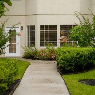 A well-maintained house entrance with a garden path leading to the front door.