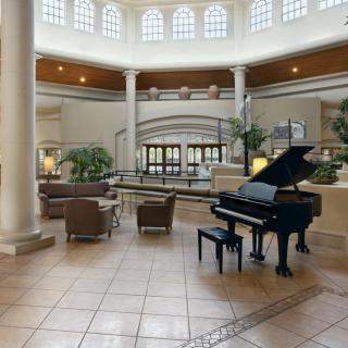 Spacious lobby with a grand piano and comfortable seating.