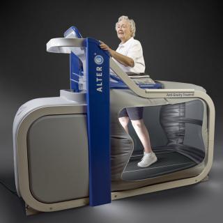 A senior person using an advanced treadmill designed for rehabilitation and fitness.