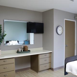 A modern hotel room featuring a simple design with essential furniture.