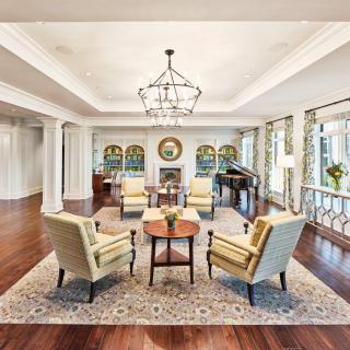 Elegant living room with hardwood floors and cozy seating around a central table.