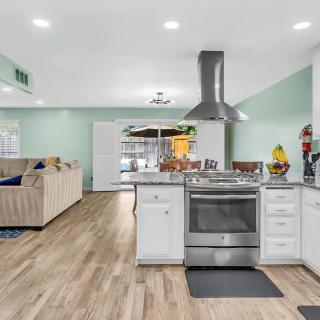 Modern open floor plan kitchen and living area with stainless steel appliances.