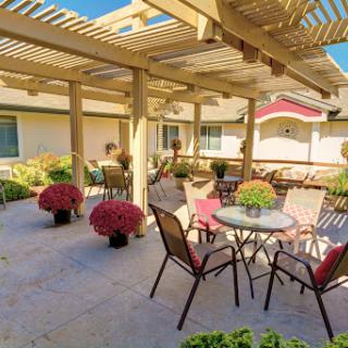 A serene outdoor patio area with comfortable seating and vibrant flower arrangements, perfect for relaxation.