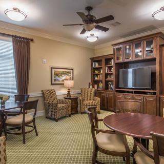 A cozy living room with comfortable seating, a TV, and bookshelves.