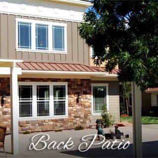 A cozy back patio area with a stylish house exterior, featuring stone and siding details.