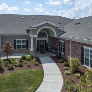 A residential building with landscaped gardens and a clear sky.