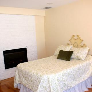 A cozy bedroom with a single bed and a fireplace.