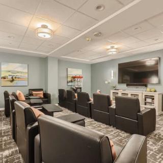 A modern home theater room with organized seating and a large screen.