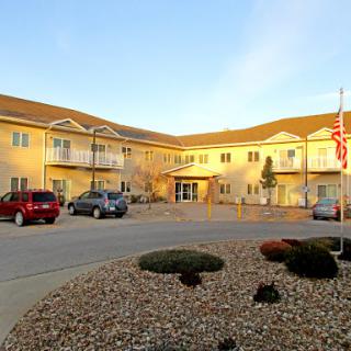 A view of a residential building with an accessible parking area and well-maintained landscaping.