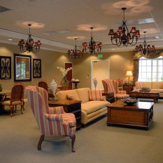 A well-decorated living room with elegant chandeliers and comfortable seating.