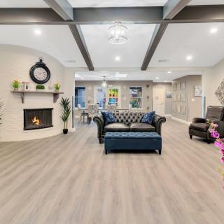 A spacious and modern living room with a cozy fireplace, featuring a stylish sofa and elegant decor.