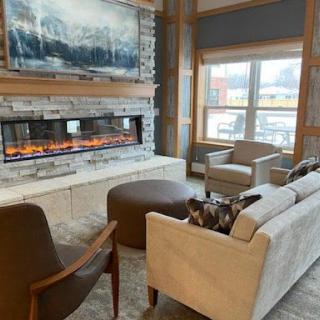 A beautifully designed living room featuring a modern fireplace, comfortable seating, and natural light.