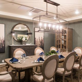 Elegant dining room with a chandelier and well-set table.