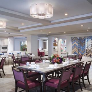 An elegant dining room with beautifully arranged tables and chairs, featuring stylish chandeliers and intricate decor.