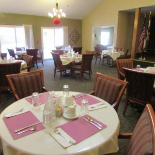 An empty dining room with neatly set tables and chairs, ready for guests.