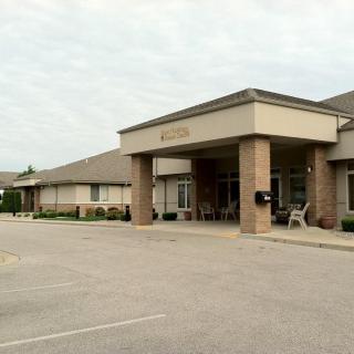 A view of a commercial building entrance with an adjacent parking lot.