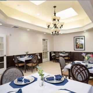 An elegant dining room with neatly arranged tables and a chandelier.