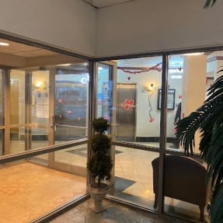 A spacious lobby showcasing glass doors and indoor greenery, creating an inviting atmosphere.