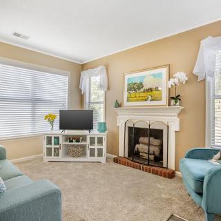 A cozy living room featuring a fireplace, comfortable seating, and tasteful decorations.