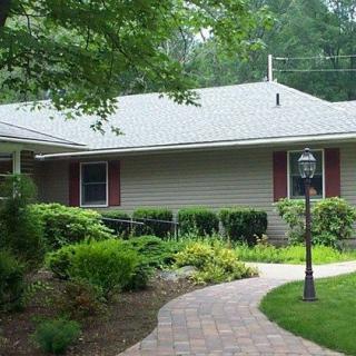 A suburban house with a landscaped garden and brick pathway.