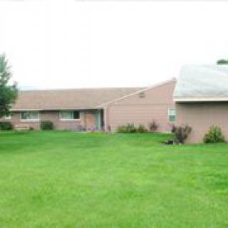 A suburban house with a large, well-maintained lawn.