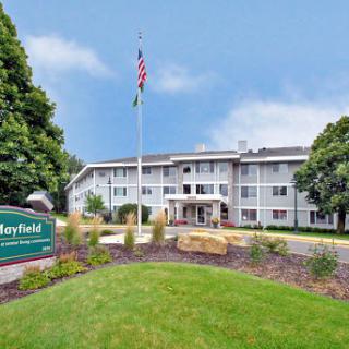 Exterior view of a hotel with landscaped grounds and a flagpole.