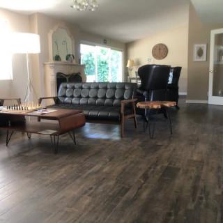 A modern living room featuring a sofa, armchairs, and a coffee table on a hardwood floor.